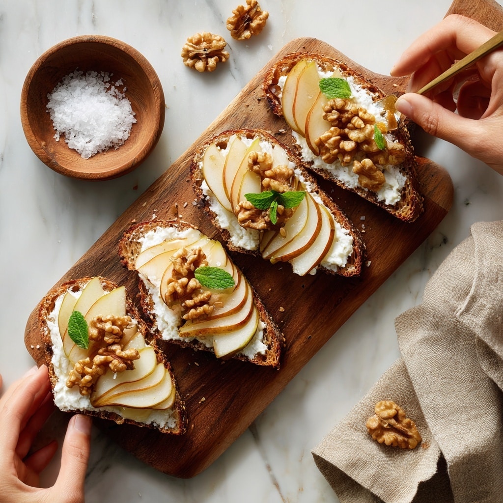 Four pieces of toasted bread with a textured, grainy crust sit on a wooden board over a white marbled surface. Each slice has a bottom layer of thick, white cottage cheese, topped with thin slices of light brown pear arranged in a small stack. On top of the pear layers are clusters of golden-brown walnuts mixed with a shiny drizzle of honey. Small green mint leaves and finely chopped green herbs are scattered over each piece, adding a fresh touch. In the background, a jar of honey is softly out of focus. photo taken with an iphone --ar 4:5 --v 7