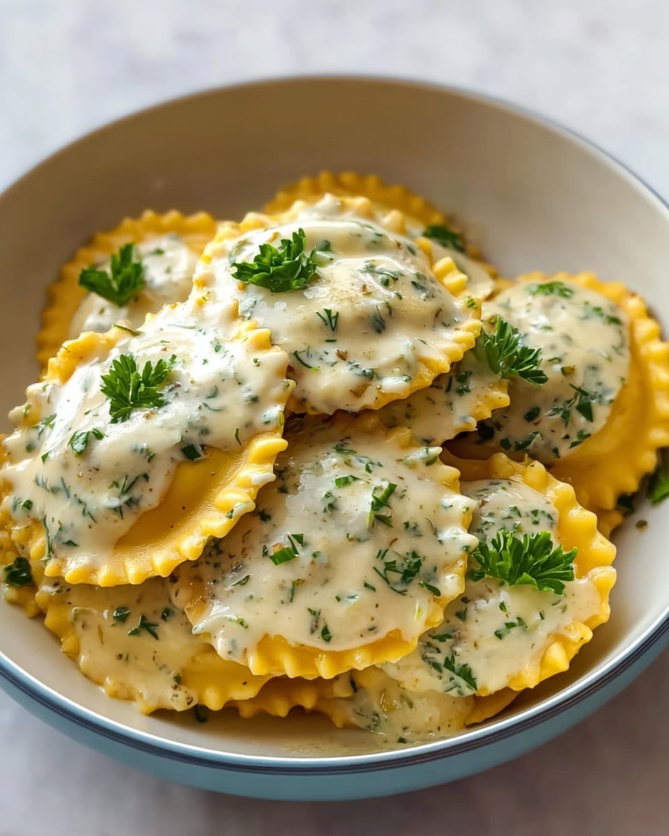A bowl filled with several round ravioli with golden yellow pasta shells, each ravioli topped with a creamy white sauce speckled with finely chopped herbs. Small pieces of bright green parsley are sprinkled on top of the sauce, adding a pop of color. The ravioli are closely stacked in the bowl, showing the smooth texture of the pasta around the edges and the scattered sauce spots. The bowl is white with a soft blue outer rim and set on a white marbled surface. Photo taken with an iphone --ar 4:5 --v 7