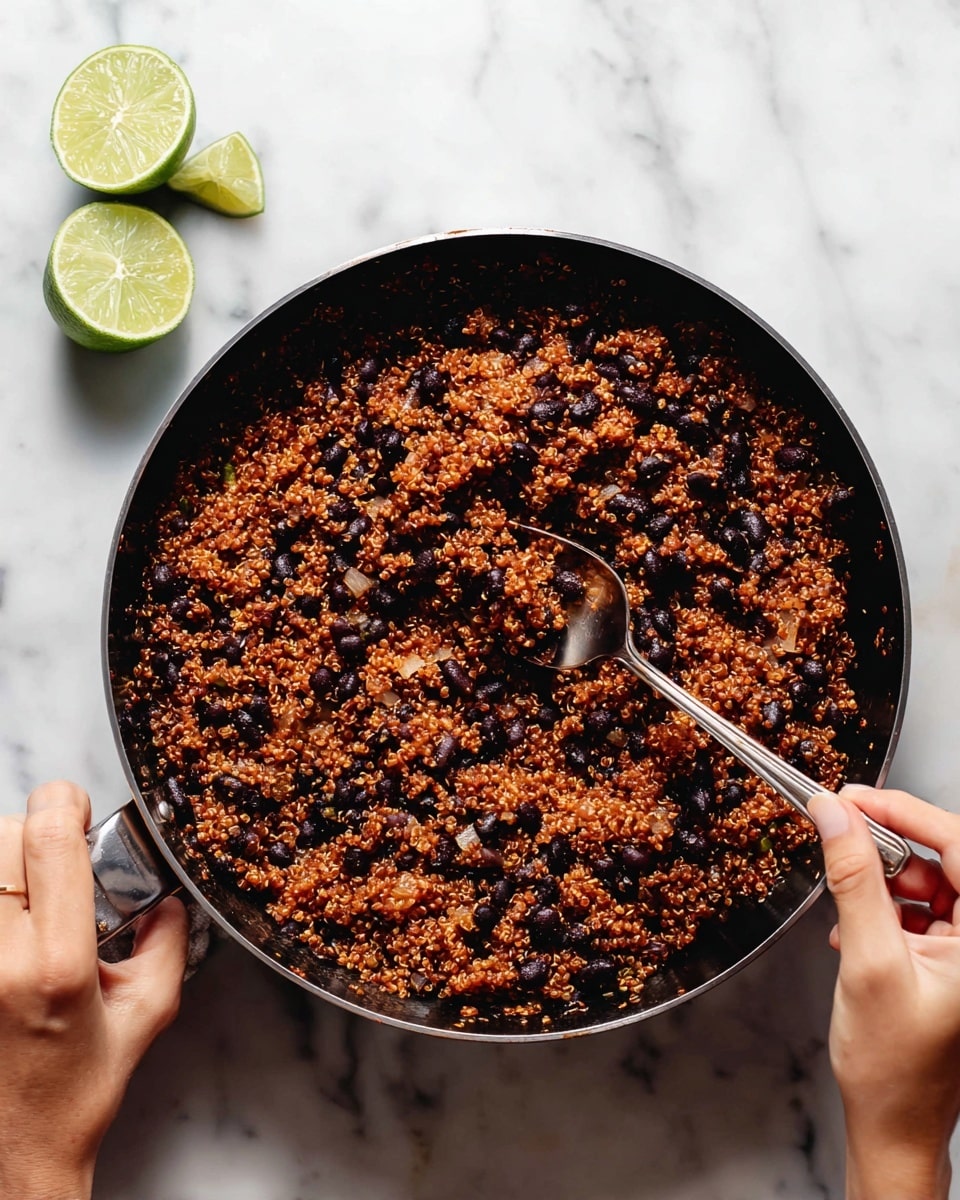 The image shows several small tacos lined up on a white marbled surface. Each taco has a slightly toasted white tortilla folded into a U shape. Inside, there is a layer of reddish-orange quinoa mixed with black beans, giving a textured and colorful look. On top of the quinoa and beans, there is a drizzle of light green creamy sauce spread unevenly. Along one side of each taco, there are few long slices of fresh avocado with a smooth texture and light green color. Small bits of chopped fresh green herbs are sprinkled over the tacos and sauce. In the background, there is a white bowl with lime wedges partially visible. Photo taken with an iphone --ar 4:5 --v 7