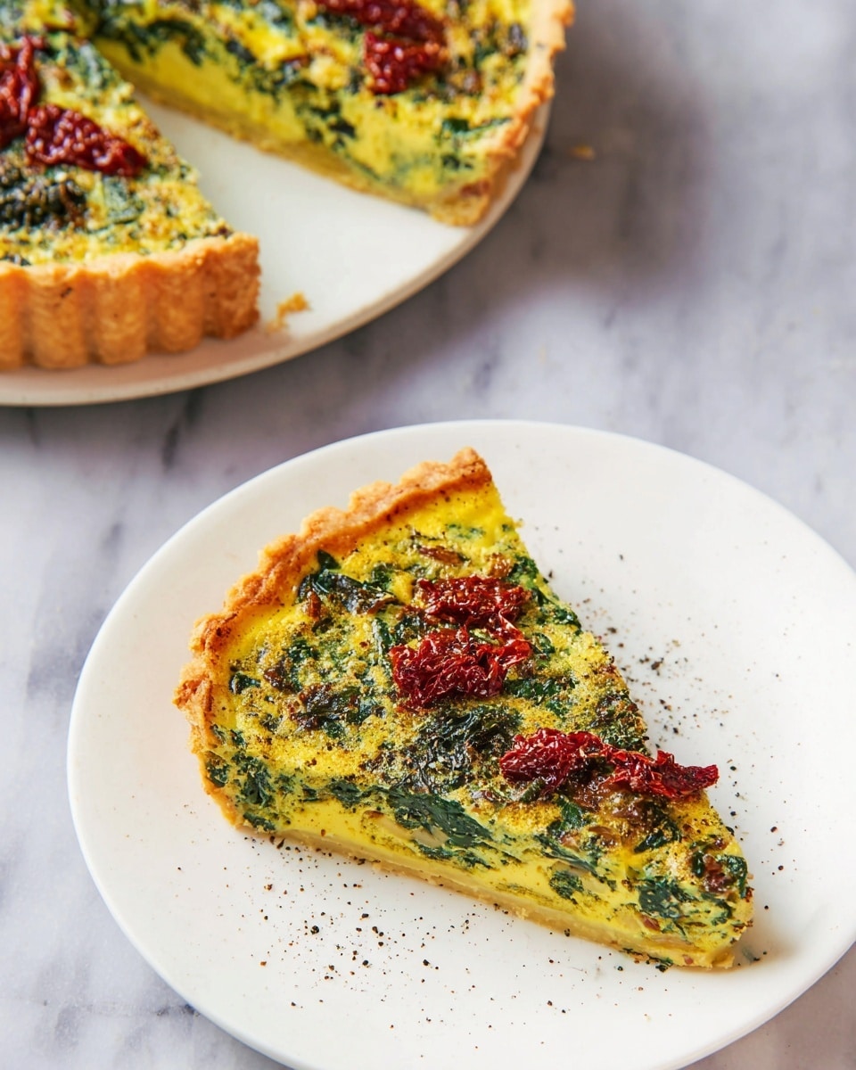 A single slice of quiche sits on a white plate with a smooth surface, resting on a few stacked white plates beneath it. The quiche has two main layers: a golden-brown crust base and a thick, creamy yellow filling mixed with dark green leafy vegetables spread evenly inside. Several pieces of deep red sun-dried tomatoes are scattered on top, adding texture and color contrast. The surface of the filling has a slightly rough texture with some brown specks of seasoning. The background features a soft, out-of-focus white marbled texture and a hint of deep purple fabric. Photo taken with an iphone --ar 4:5 --v 7