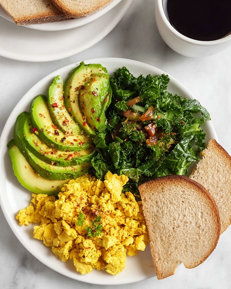 A white plate with four parts of food arranged in sections: the bottom right has two slices of toasted bread with a light golden crust, the bottom left holds bright yellow scrambled tofu with a crumbly texture, the top left shows sliced avocado fanned out with visible seasoning of red pepper flakes and pepper, and the top middle contains cooked dark green kale with bits of translucent onions mixed in. Next to the plate, there is a white cup filled with black coffee, all set on a white marbled texture surface. photo taken with an iphone --ar 4:5 --v 7