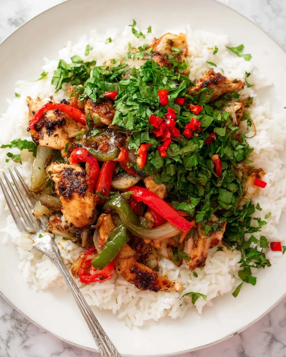 A white plate holds a meal with three main layers: at the bottom is a bed of plain white rice with fluffy texture; on top of the rice are cooked pieces of chicken, green and red bell peppers, and grilled onions, all having a slightly charred and browned look; the upper layer is fresh green chopped herbs mixed with small red chili pieces, adding a vibrant pop of color. A silver fork rests on the side of the plate, and the whole scene is set on a white marbled surface. photo taken with an iphone --ar 4:5 --v 7